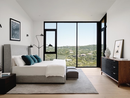 In one of the bedrooms, floor-to-ceiling windows allow the tree view to be enjoyed from the bed.