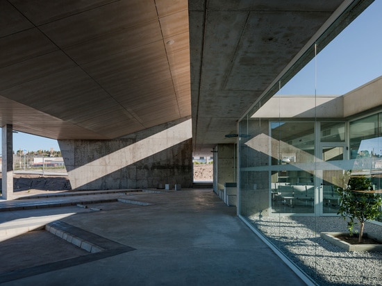 parking spaces are enclosed beneath a slanted roof canopy