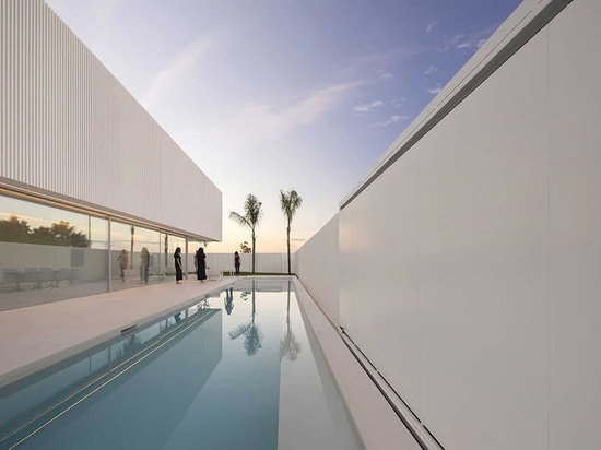 a rectungular pool reflects the blue sky