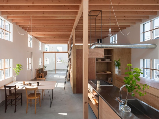 A staircase lands on a desk inside House in Hikone by Tato Architects