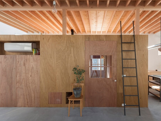 A staircase lands on a desk inside House in Hikone by Tato Architects