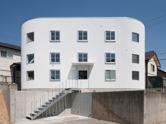 A staircase lands on a desk inside House in Hikone by Tato Architects