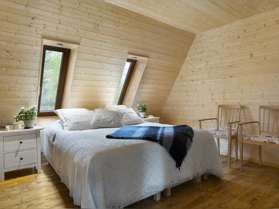 Two rectangular windows suffuse this cozy bedroom with light.