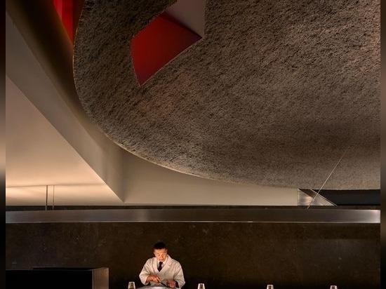 Smoky monochromatic grey interior is punctuated by a peek into a red private dining room above.