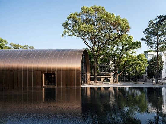 the multi-functional cultural space is enveloped inside an arch made entirely out of metal