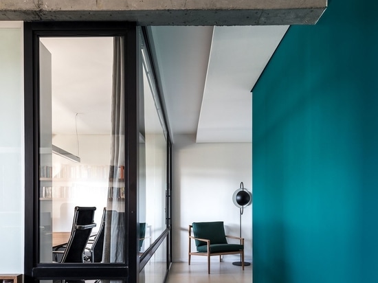 Framed glass walls bring in natural light while the dark green walls hold your attention