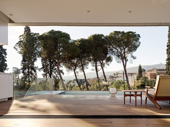 View of the deck, pool area and the landscape beyond from the living space