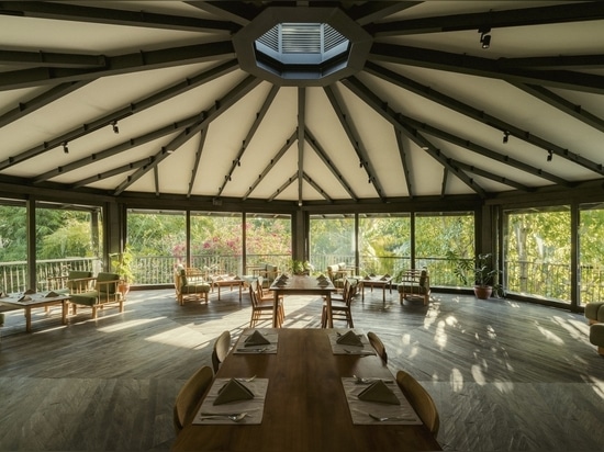 large glass sliding doors let breathtaking views of the forest flood the interior