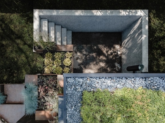 A green roof and terraced planting extends the natural topography