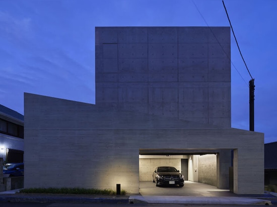 Dynamic curtain of concrete walls of varying heights engulfs japanese home in tranquility