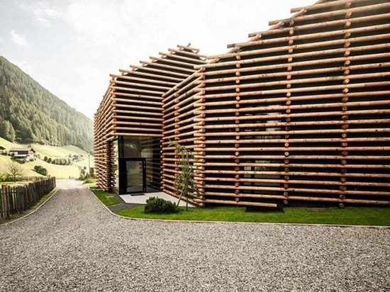 DEAR Studio adapts old hay barns into modern larch log-clad hotel in italian Alps