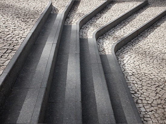 A monochrome palette of traditional Portuguese mosaic paving and granite edging merges with modern building techniques for precision at curves and geometric edges