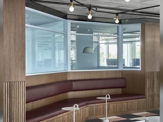 ln response to staff requests for comfortable spaces, Studio Tate designed banquettes in walnut timber and burgundy leather opposite the reception desk.