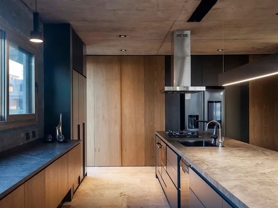 The kitchens features raw concrete and stone floors