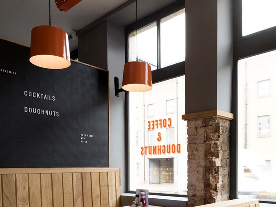 the blue formica branded table-tops are set between the oak banquette seating