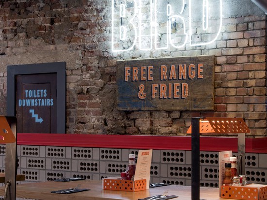 the mismatched brick wall is a perfectly contrasting backdrop to the bright white neon BIRD logo