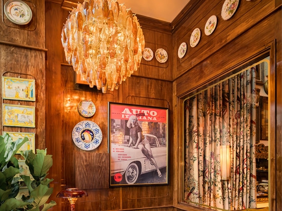 A grand Murano glass chandelier composed of poliedri in delicate glacé, amber, and smoky hues graces the reception area of 'La Bellezza' restaurant, adding elegance and timeless charm to the space.