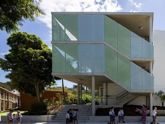 Facing the street, the end of the red-brick building is partially wrapped by a generous staircase and perforated panels.