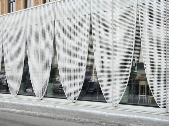 A hotel in Sweden gets a pavilion draped with perforated aluminium