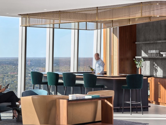 Decorative woven wire mesh installed in corporate interior design as a gantry over a bar