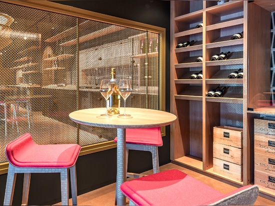 A contemporary wine tasting space features M22-83 brass woven wire mesh as a space divider for a tasting room.