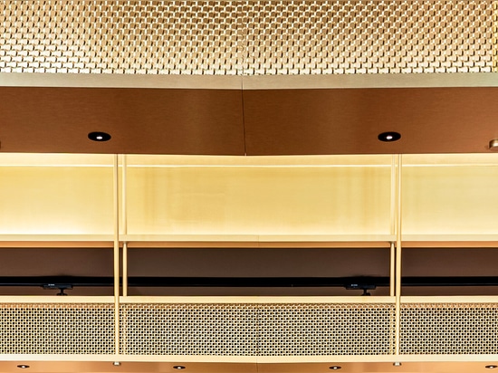 A contemporary wine tasting space features M22-83 brass woven wire mesh as a ceiling gantry that forms a sculptural canopy above the bar.