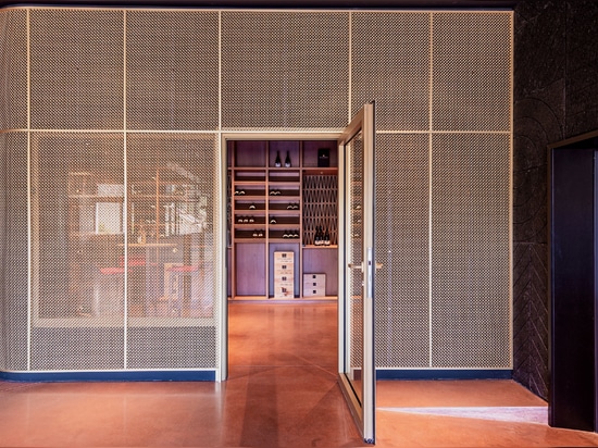 A contemporary wine tasting space features M22-83 brass woven wire mesh as a space divider for a tasting room.