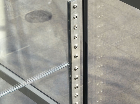 The 7m long glass fins bear the load of the all-glass façade. The connection parts are kept unobtrusive so that the transparency of the building envelope is hardly affected.