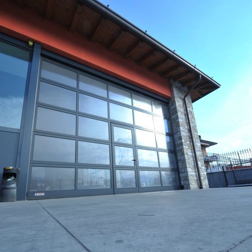 Porta industrial seccionada - SECTIONAL GLASS - Moreschi Chiusure Industriali S.r.l. - em alumínio / em aço / em aço galvanizado